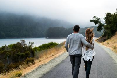 Couple walking together along a lakeside trail, symbolizing daily rituals that keep relationships strong