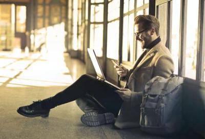 a guy lookig up on his computer How to Become a Professional Traveler and Make Money