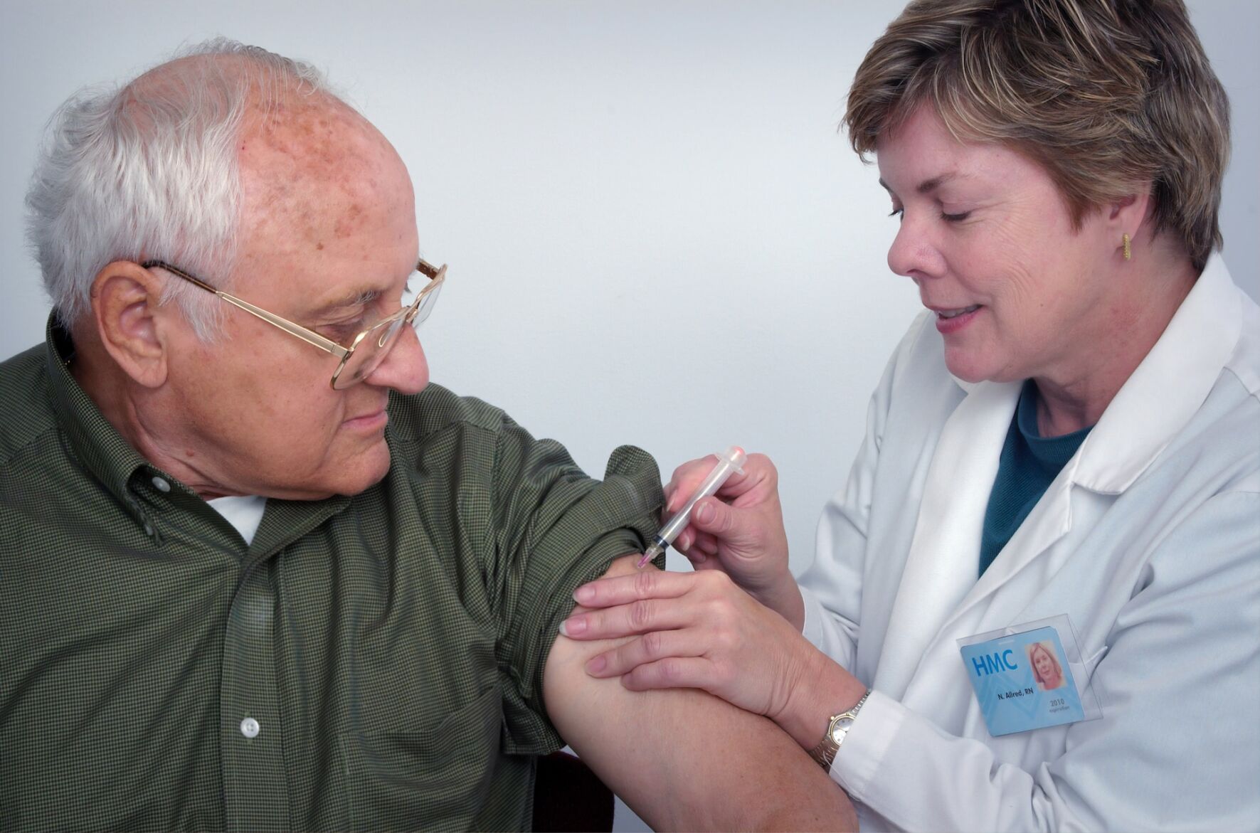 Woman cares for loved one by injecting syringe into arm