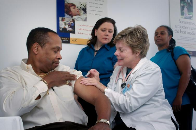 A healthcare professional administers a shot to a patient