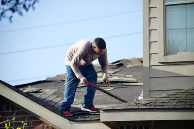 Man repairs roof to restore roof's integrity