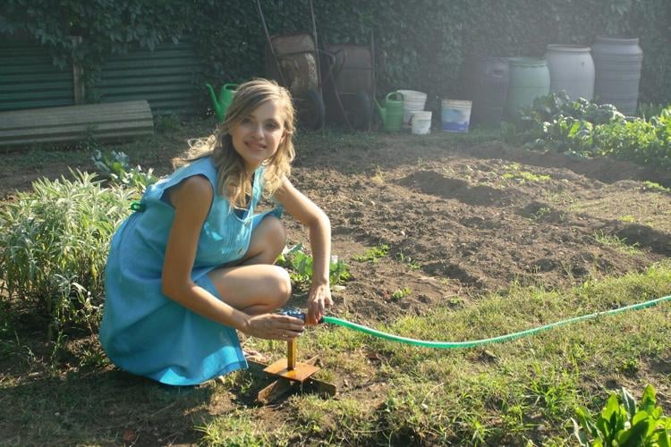 Woman works in a garden that fits her home decor