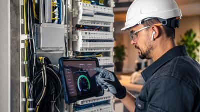 Electrician inspecting a circuit breaker panel in a home electrical system
