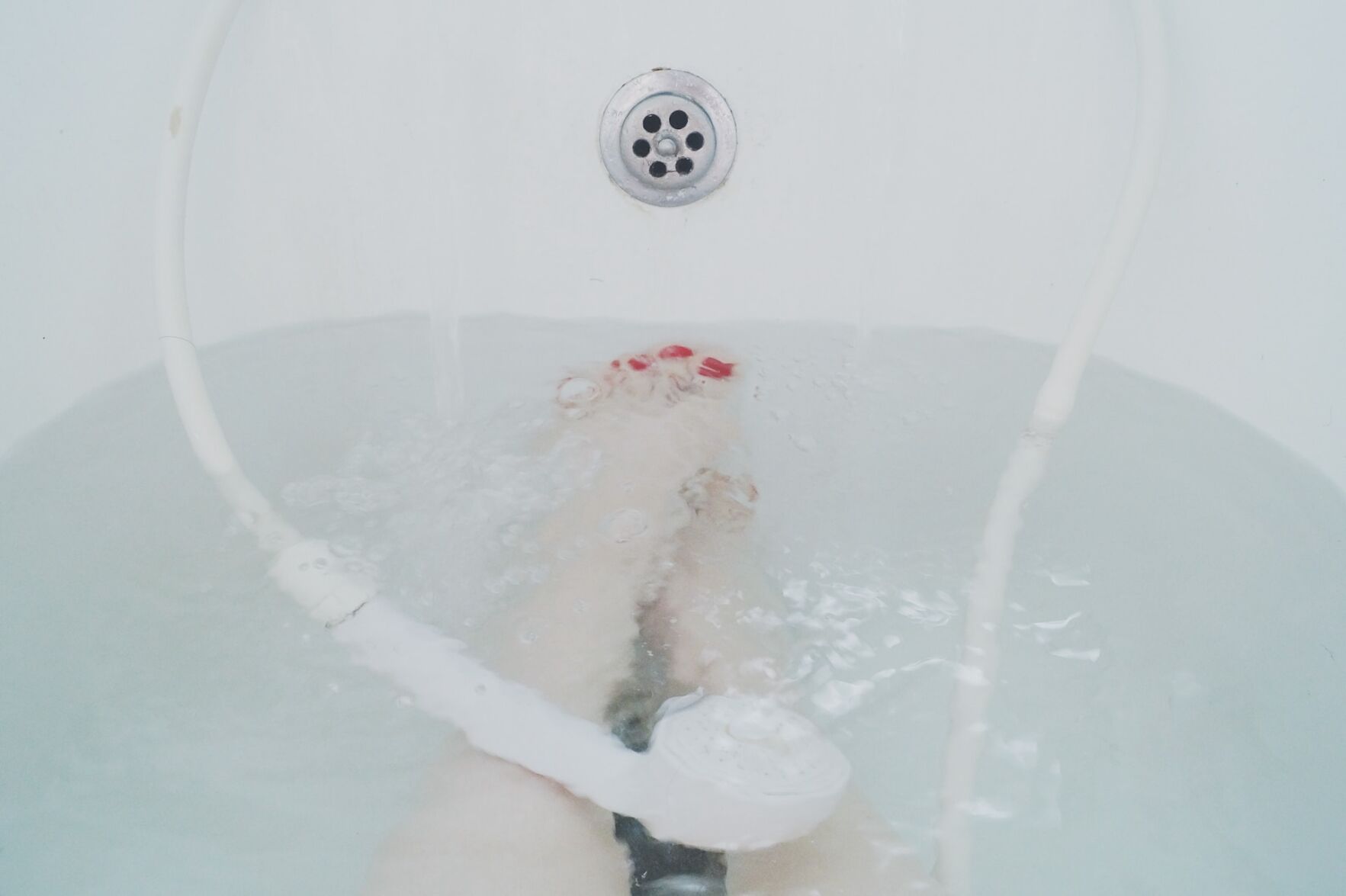 Person sits in bathtub with unclogged drain
