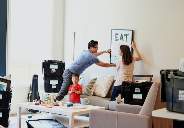 Couple hang up art in their newly purchased first home