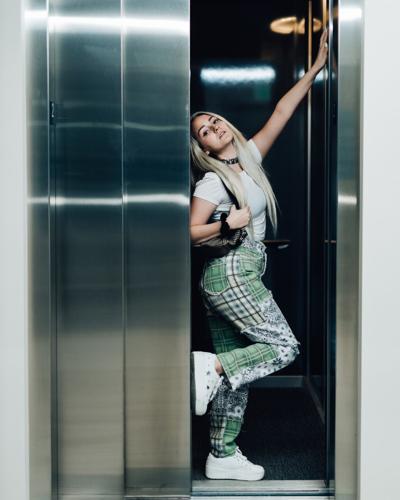 A young woman standing in the doorway of a residential elevator a whole other level to luxury