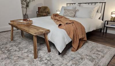 A bedroom with a perfectly sized and colored rug