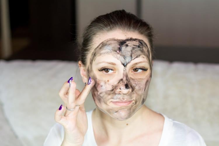 Woman applies face mask as part of her skincare routine