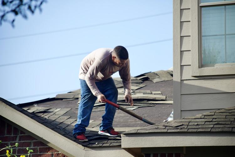 Man fixes shingles on a roof