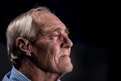 Man wearing hearing aid to amplify and refine sounds