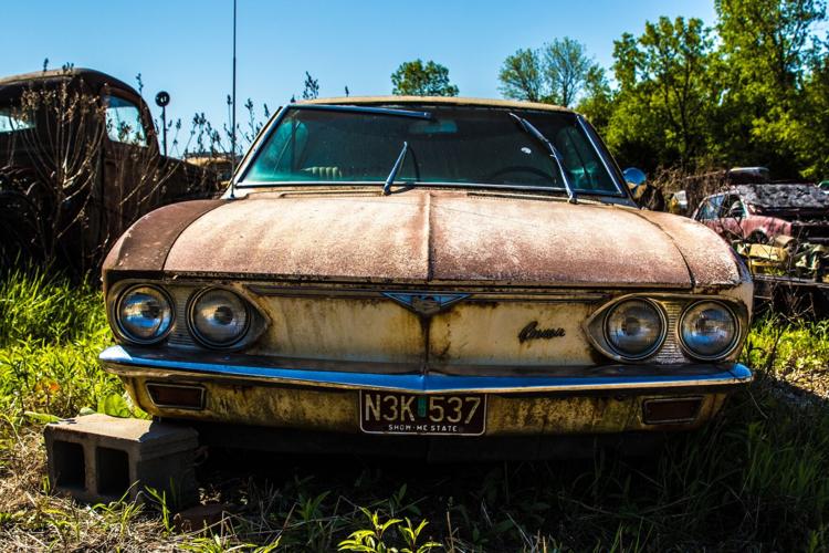 Broken down car sits around in junk yard