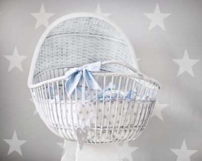 Bassinet in front of star-studded nursery accent wall