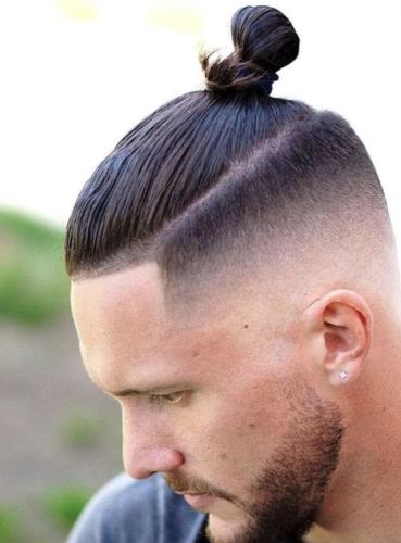 Man wears a man bun during the 2010s, to mixed reviews