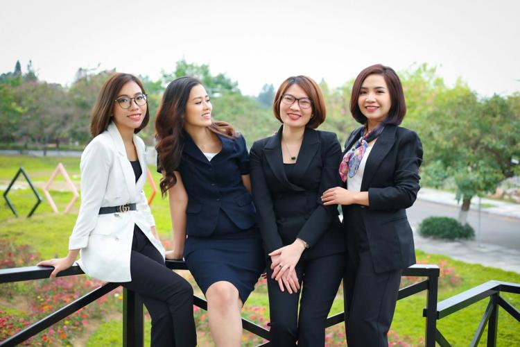 4 women 3 wearing pantsuits
