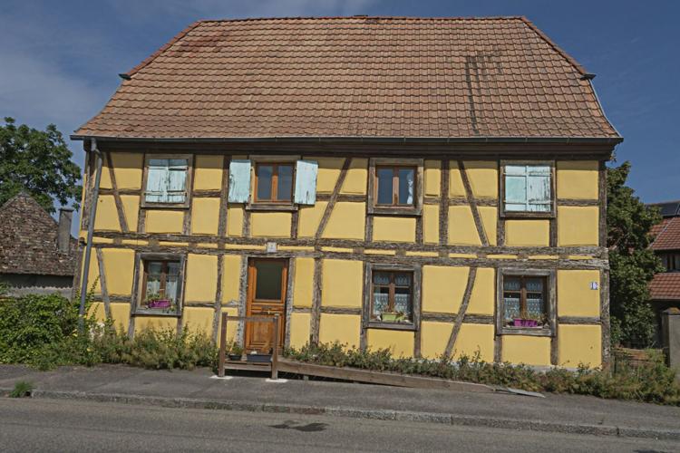 Yellow house with aesthetically appealing brown roof