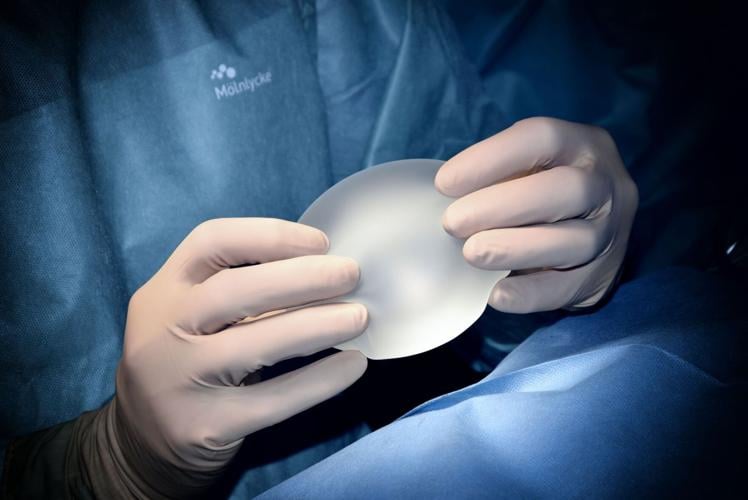 Doctor holds silicon implant for plastic surgery procedure