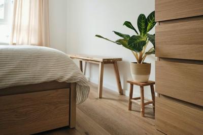Room with a wide range of wood, including the bedframe, floor, and furniture