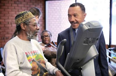 Kweisi Mfume chats with Charles Lowder in Baltimore on Jan. 9 during a campaign stop.
