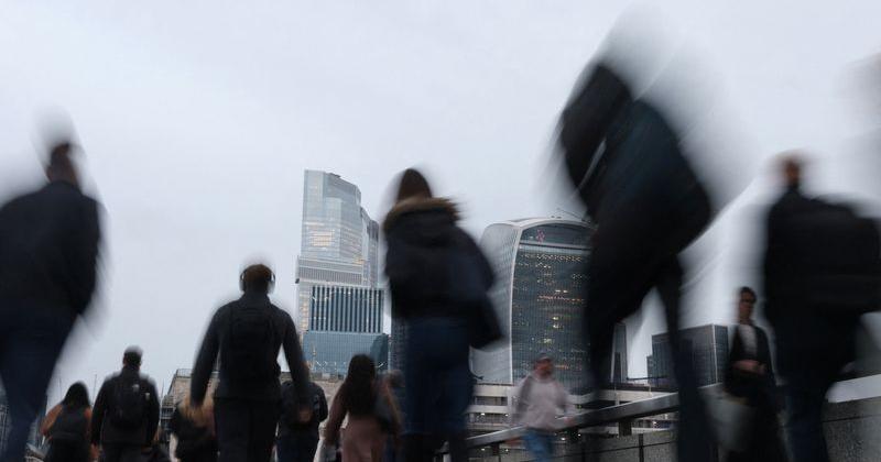 Workers cross London Bridge during the morning rush-hour in London