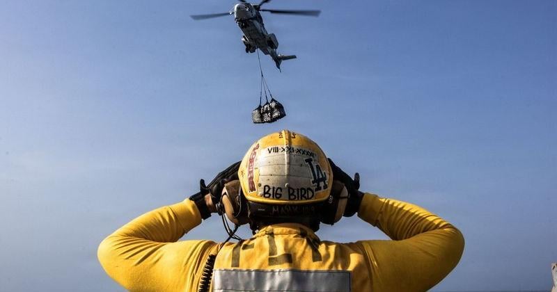 A U.S. Navy sailor directs a helicopter on the flight deck of the aircraft carrier USS Abraham Lincoln on Aug. 16, 2026. The carrier returned home to San Diego on Oct. 8, after a 321-day marathon deployment that saw its crew brave deteriorating conditions while operating in an active combat zone as part of the Iran war.