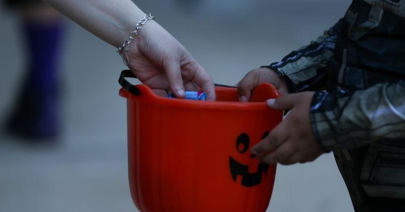 A child receives candy from a volunteer at the annual Halloween with the Hooks at Whataburger Field in Corpus Christi on Oct. 24, 2024.