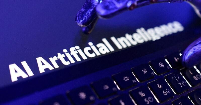 FILE PHOTO: Illustration shows words "AI Artificial Inteligence", keyboard and a robotic hand