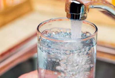 Filling up a glass with drinking water from kitchen tap (copy) (copy)