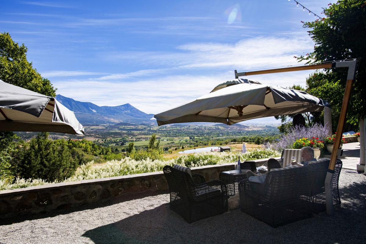 Customers drink a glass of wine and enjoy the view of the valley below at the Azura winery outside Paonia. Azura is one of 12 wineries in the Paonia area. photos by CHRISTIAN MURDOCK, THE GAZETTE
