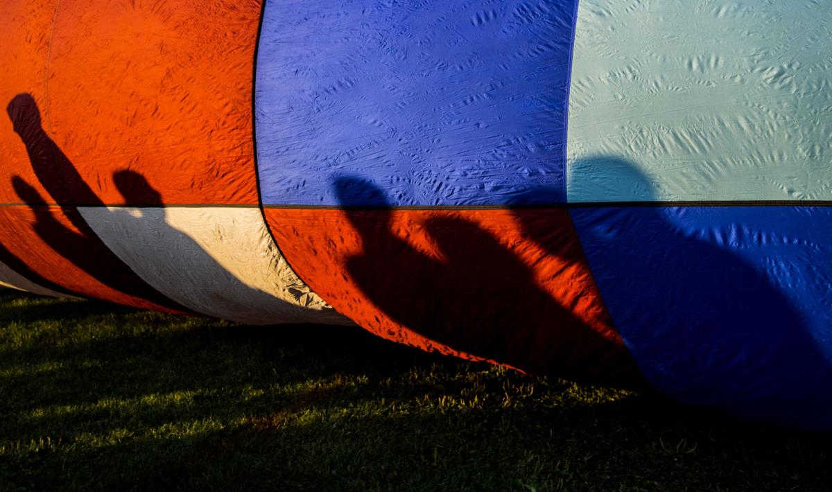 Shadows of spectators are casted on a balloon Saturday, Sept. 2, 2017, during the Colorado Springs Labor Day Lift Off in Memorial Park. The balloon festival runs through Monday morning. (The Gazette, Christian Murdock)