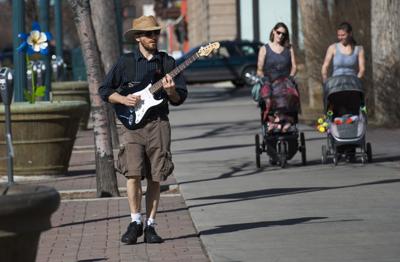 Local guitarist Benjamin Pratt sarenades pedestrians with his guitar and battery-powered amp as he walks along Tejon Street in downtown Colorado Springs Friday, Feb. 10, 2017, on a record-setting day. Friday marked the hottest Febuary day with as the te...