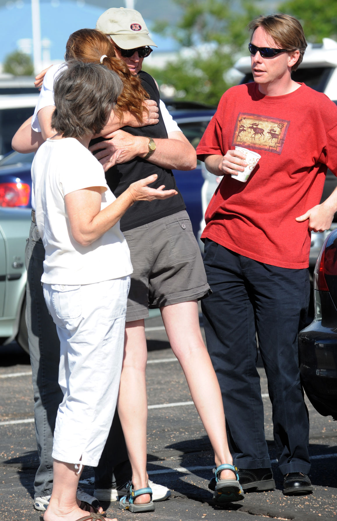 Terry Stokka hugs Jaenette Coyne before a press conference Wednesday, June 12, 2013, during the second day of the Black Forest Fire. Coyne and her husband, Kristian Coyne, right, lost their home Tuesday. Pictured on the left, is Terry's wife Artha. (The Gazette, Christian Murdock)