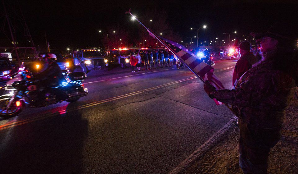 Rick Beckner salutes the procession for El Paso County Sheriff's Deputy Micah Flick while holding his flag at half-mast on the side of the road outside of the El Paso County Coroners Office Officers on Monday, February 5, 2018. Flick died in a shootout during a stolen car investigation.(Nadav Soroker, The Gazette)