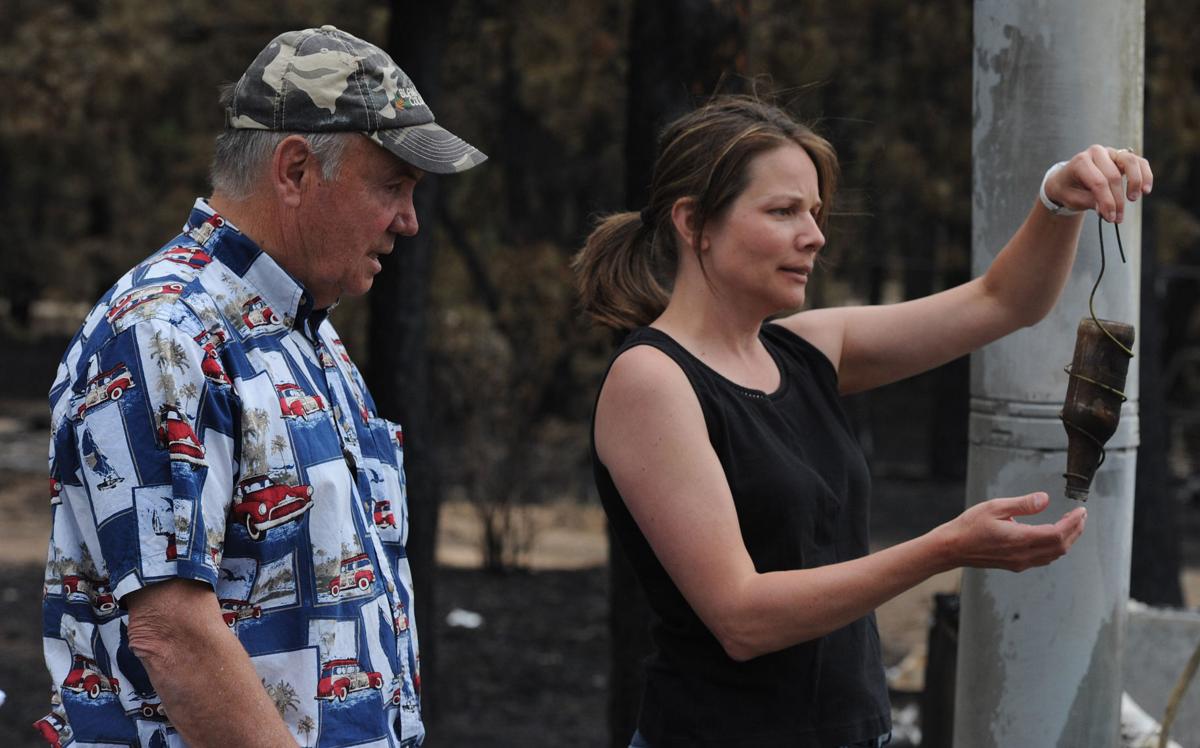Renee Seay finds what is left of a birdfeeder that she gave her father, Dick Hoffman (left). Hoffman lost his home in the Black Forest Fire in Colorado . Homeowners that are north of Burgess Rd. and east of Vollmer Rd. in the Black Forest burn area were able to return to their homes today on Tuesday, June 18, 2013.(Jerilee Bennett/The Gazette)