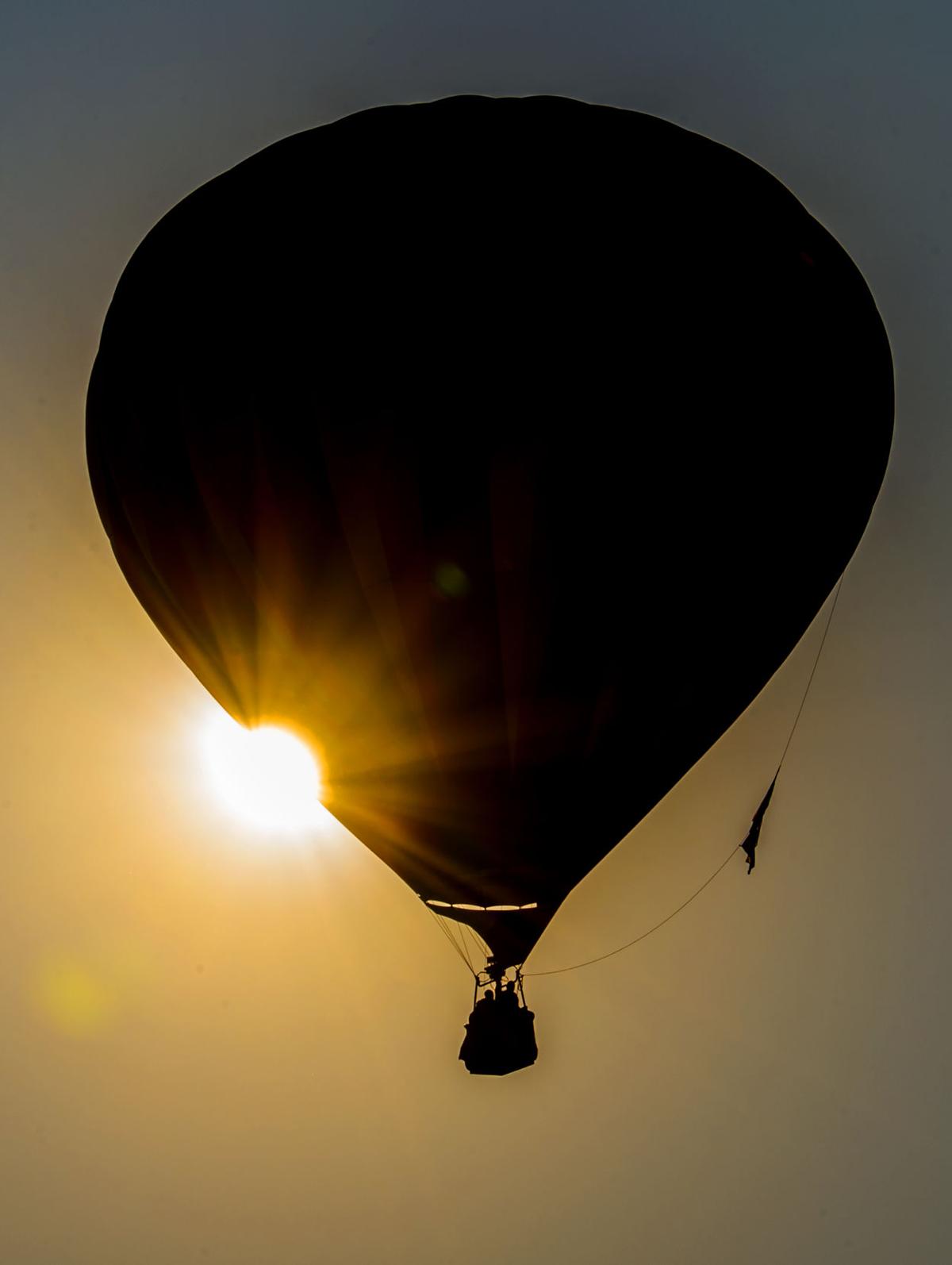 A balloon eclipses the rising sun as it takes off Saturday, Sept. 2, 2017, during the Colorado Springs Labor Day Lift Off in Memorial Park. The balloon festival runs through Monday morning. (The Gazette, Christian Murdock)