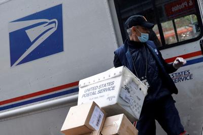 FILE PHOTO: United States Postal Service (USPS) worker unloads packages in Manhattan during outbreak of coronavirus disease (COVID-19) in York (copy)