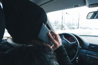 Woman using cell phone while driving