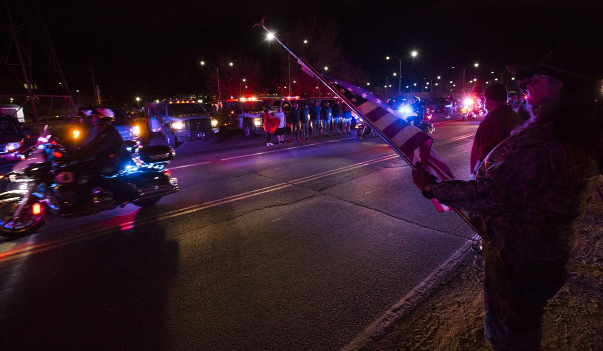 Rick Beckner salutes the procession for El Paso County Sheriff's Deputy Micah Flick while holding his flag at half-mast on the side of the road outside of the El Paso County Coroners Office Officers on Monday, February 5, 2018. Flick died in a shootout during a stolen car investigation.(Nadav Soroker, The Gazette)
