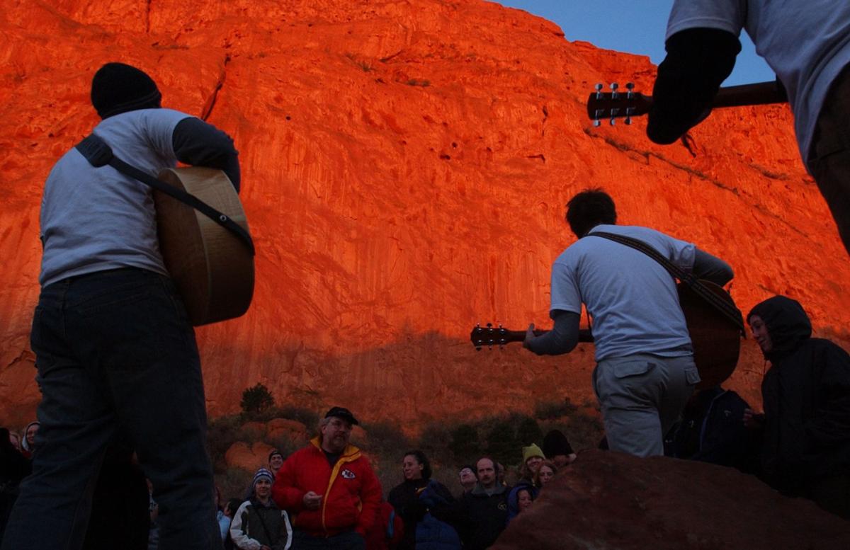 The sun makes its presence known by turning the sandstone walls in Garden of the Gods bright orange as members of New Life Church play songs to a crows of approximately 150 during the unofficial Easter Sunrise Service on Sunday, April 20, 2003. Approximately 150 people gather for the unofficial 84th annual Easter Sunrise Service at Garden of the Gods on Sunday, April 20, 2003. The service was officially canceled this year due to the cost of putting the event on. Most of the people who showed up this year were members of New Life Church. They gathered to worship through song and prayer. Photo by David Bitton