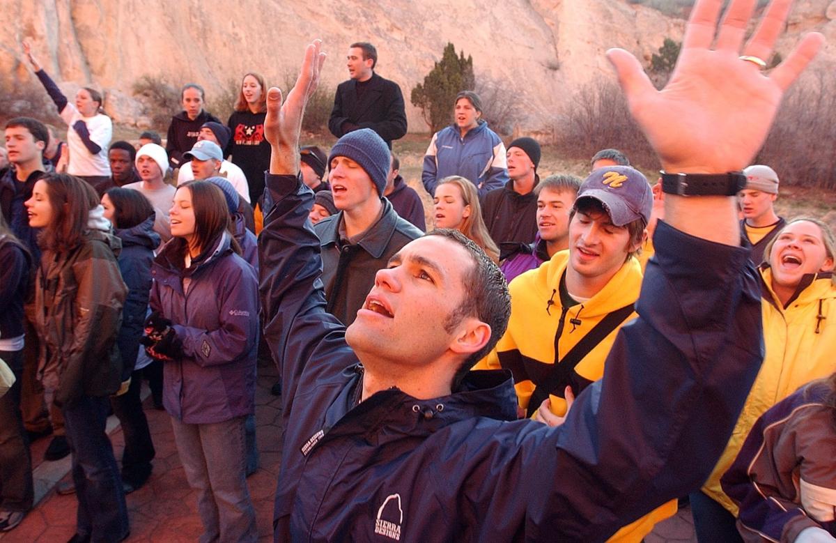 Aaron Stern, a college pastor at New Life Church and unofficial organizer of this years Easter Sunrise Service at Garden of the Gods, raises his hands in worship on Sunday, April 20, 2003. Approximately 150 people gather for the unofficial 84th annual Easter Sunrise Service at Garden of the Gods on Sunday, April 20, 2003. The service was officially canceled this year due to the cost of putting the event on. Most of the people who showed up this year were members of New Life Church. They gathered to worship through song and prayer. Photo by David Bitton