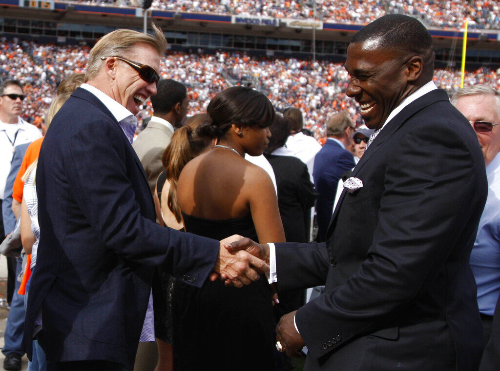 Former NFL quarterback John Elway, center, greets fans while