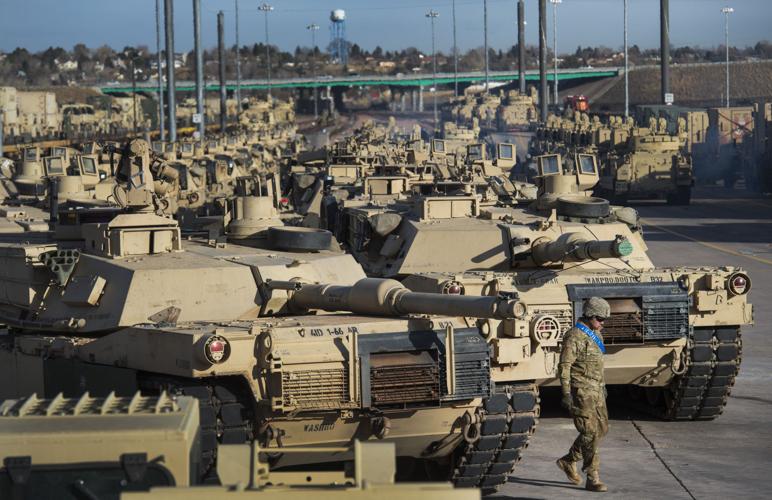 A soldier walks past a line of M1 Abrams tanks Tuesday, Nov. 29, 2016, as the 3rd Armored Brigade Combat Team, 4th Infantry Division loads track and wheeled vehicles onto rail cars at Fort Carson. The 2,800 vehicles are bound for nine countries in centr...