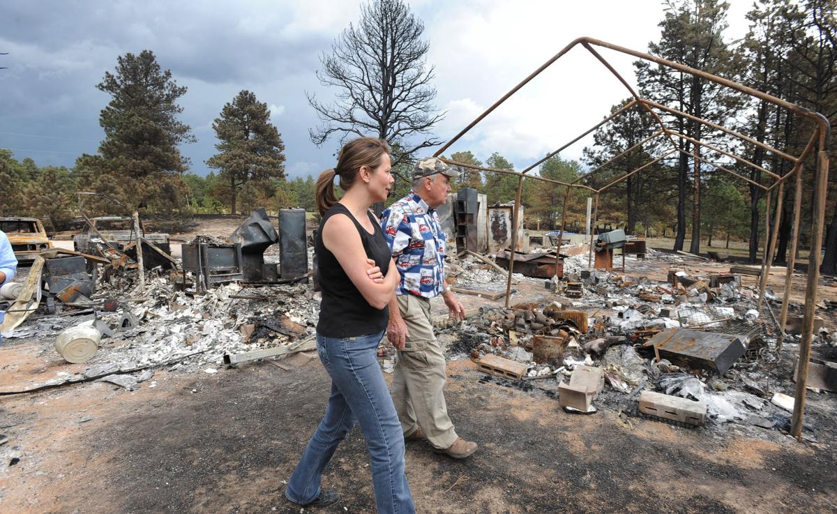 Black Forest homeowner Dick Hoffman takes his daughter, Renee Seay, on a tour of what was her childhood home. Hoffman lost his home in the Black Forest Fire in Colorado. Homeowners that are north of Burgess Rd. and east of Vollmer Rd. in the Black Forest burn area were able to return to their homes today on Tuesday, June 18, 2013.(Jerilee Bennett/The Gazette)