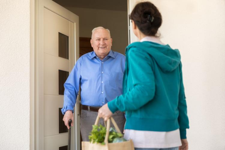 Home caregiver – woman helping senior man