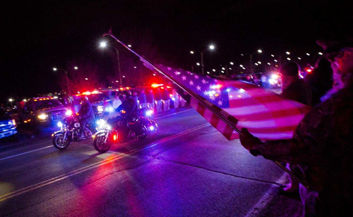 Rick Beckner salutes the procession for El Paso County Sheriff's Deputy Micah Flick while holding his flag at half-mast on the side of the road outside of the El Paso County Coroners Office Officers on Monday, February 5, 2018. Flick died in a shootout during a stolen car investigation. (Nadav Soroker, The Gazette)