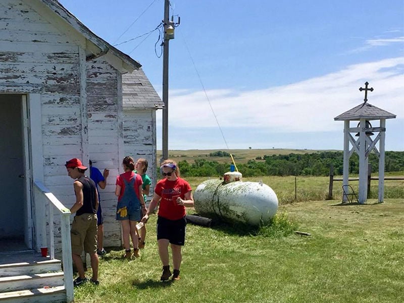 Volunteers work on the St. Paulâs Episcopal Church in Norris, SD, in June 2016. The bell from this tower, at right, was stolen between Dec. 31, 2017, and Jan. 3, 2018. The tower was pulled over, and the cross at the top, a wooden carving of a Niobrara Cross, was broken into three pieces. Photo by Carrie Thomas