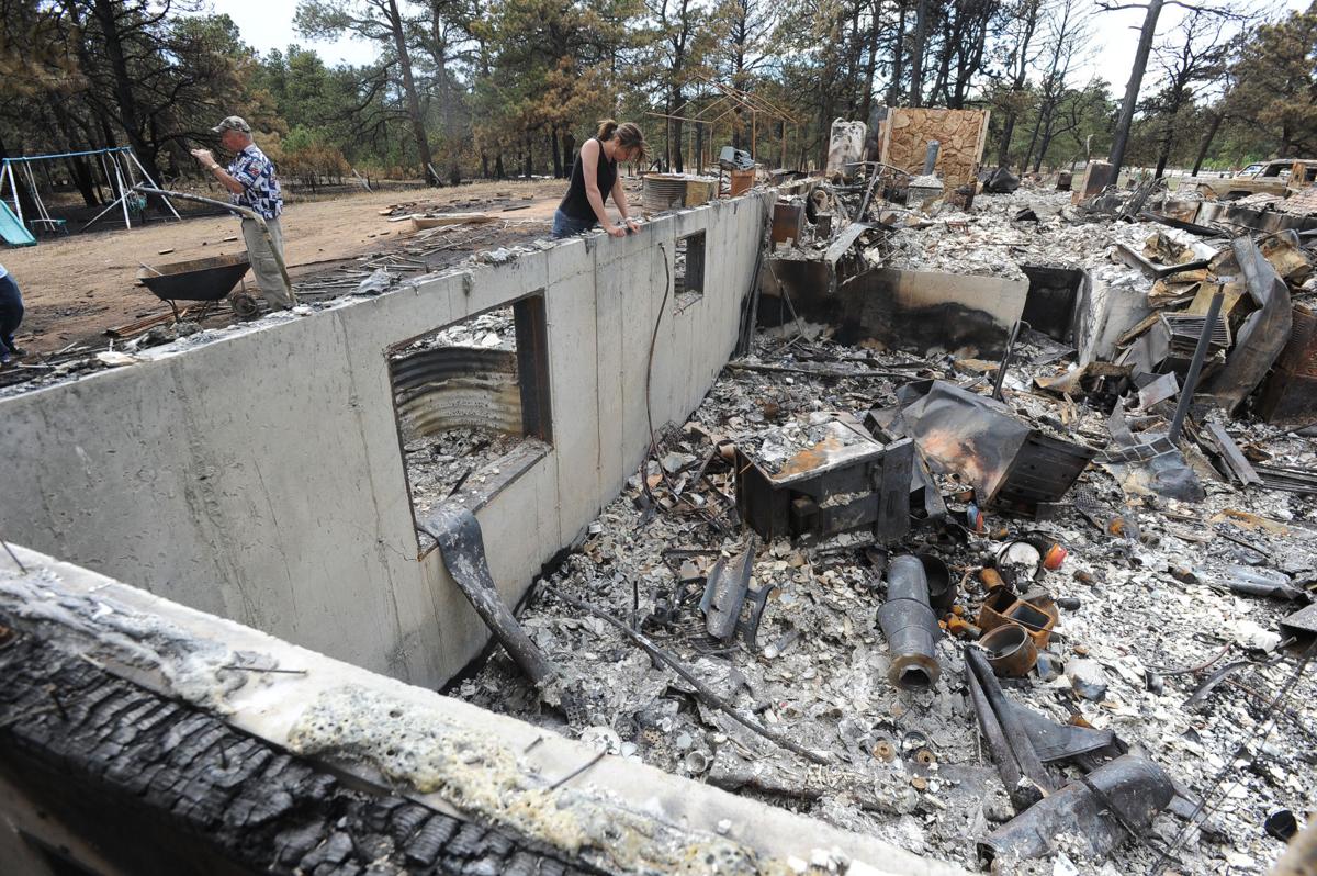 Renee Seay finds what is left of a birdfeeder that she gave her father, Dick Hoffman (left). Hoffman lost his home in the Black Forest Fire in Colorado . Homeowners that are north of Burgess Rd. and east of Vollmer Rd. in the Black Forest burn area were able to return to their homes today on Tuesday, June 18, 2013.(Jerilee Bennett/The Gazette)