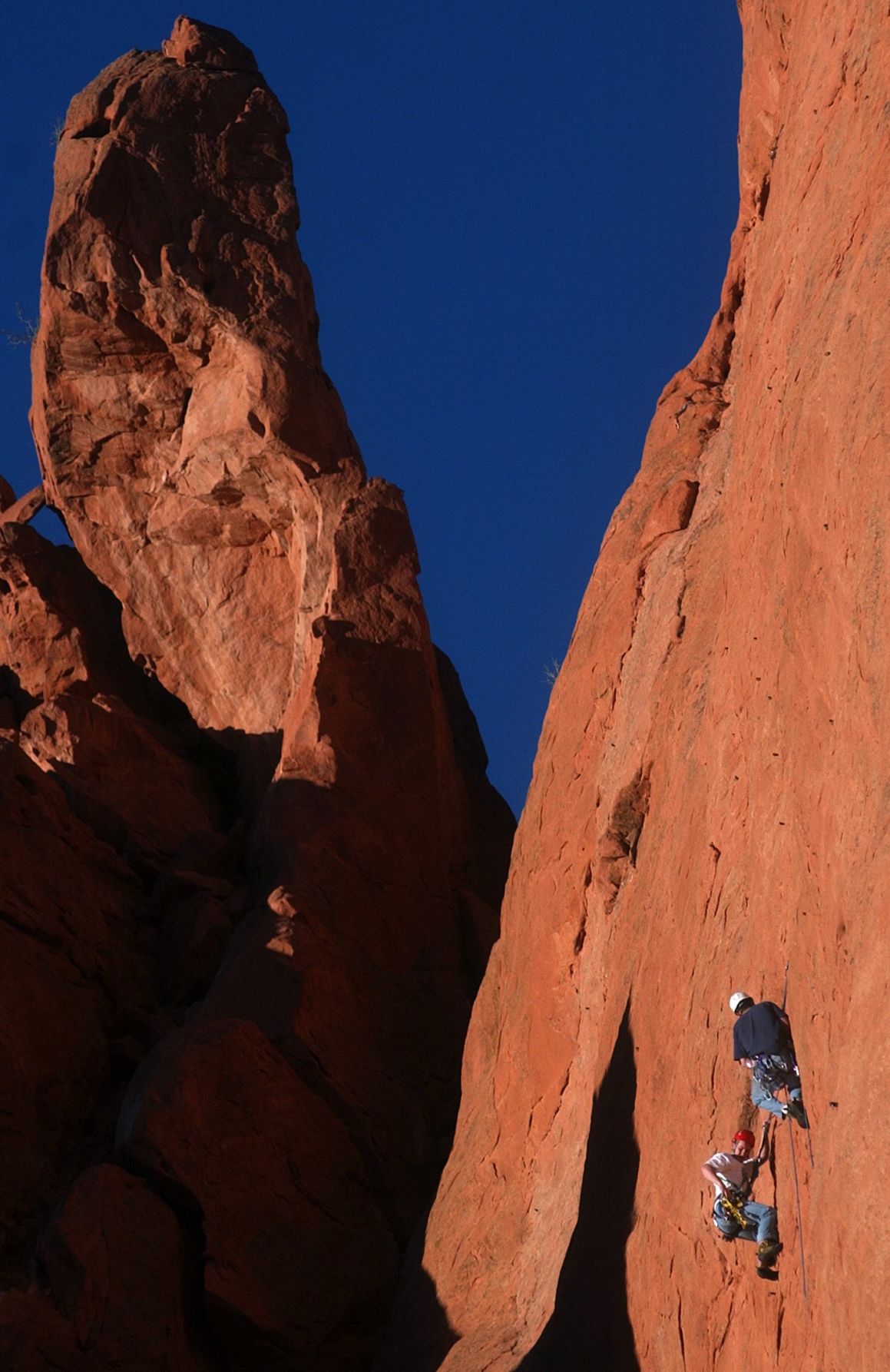 Rock climbers take advantage of a clear late afternoon on Thursday, Jan. 29, 2004 to scale the North Gateway Rock in the Garden of the Gods just below the Kissing Camels rock formation that sits above them. After a few days of below average temperatures the area finally heated up enough for visitors to stroll throught the park. Temperatures are expected to take a dip this weekend. The Gazette, Bryan Oller