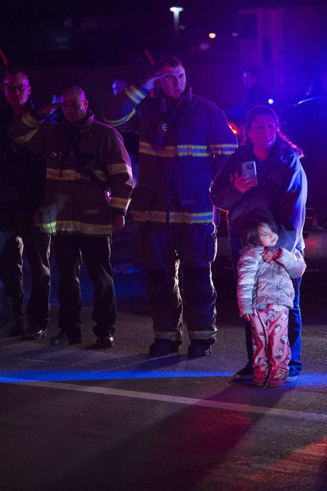 Firefighters salute the procession for El Paso County Sheriff's Deputy Micah Flick outside of the El Paso County Coroners Office Officers on Monday, February 5, 2018. Flick died in a shootout during a stolen car investigation. (Nadav Soroker, The Gazette)
