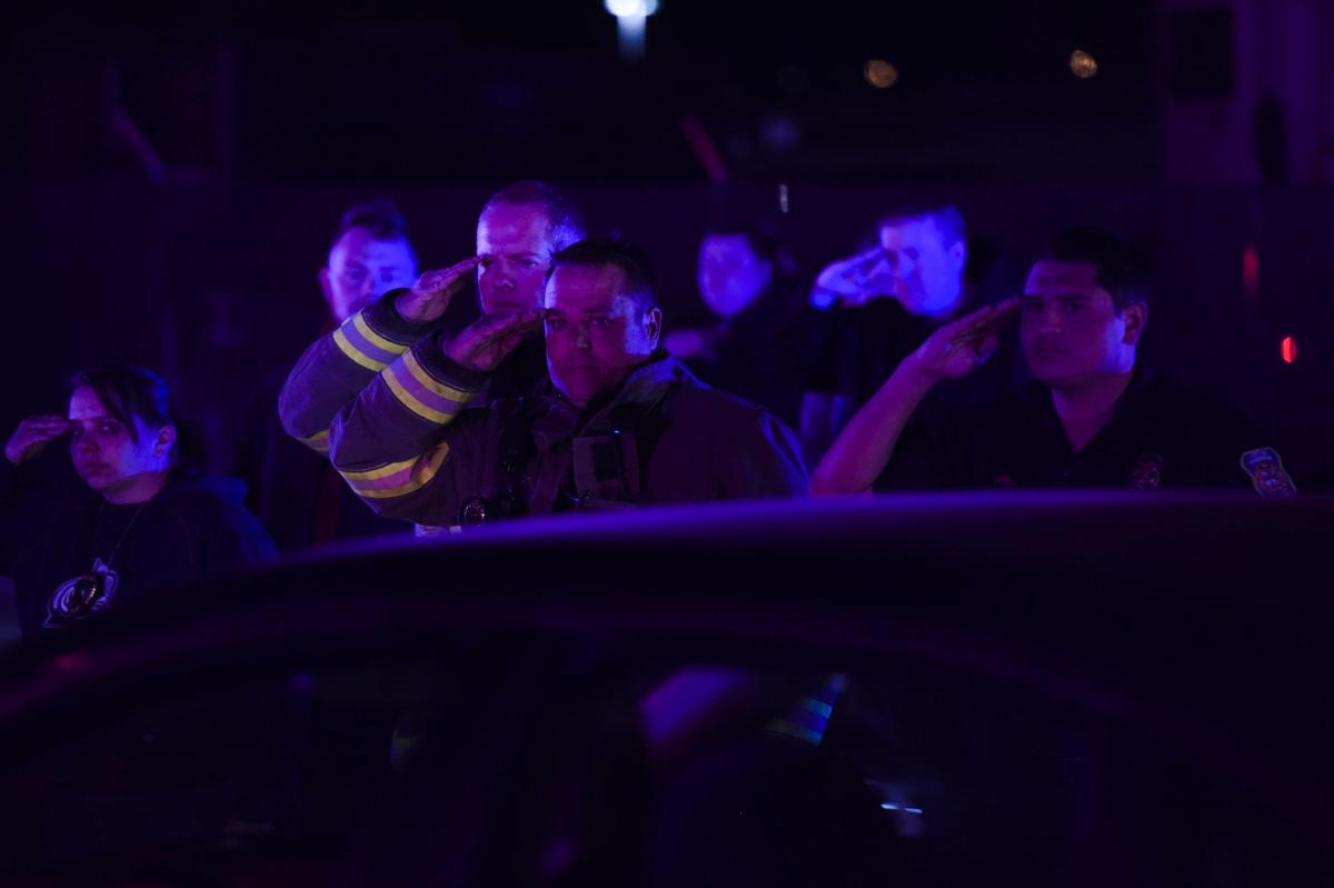 Firefighters salute the procession for El Paso County Sheriff's Deputy Micah Flick outside of the El Paso County Coroners Office Officers on Monday, February 5, 2018. Flick died in a shootout during a stolen car investigation. (Nadav Soroker, The Gazette)