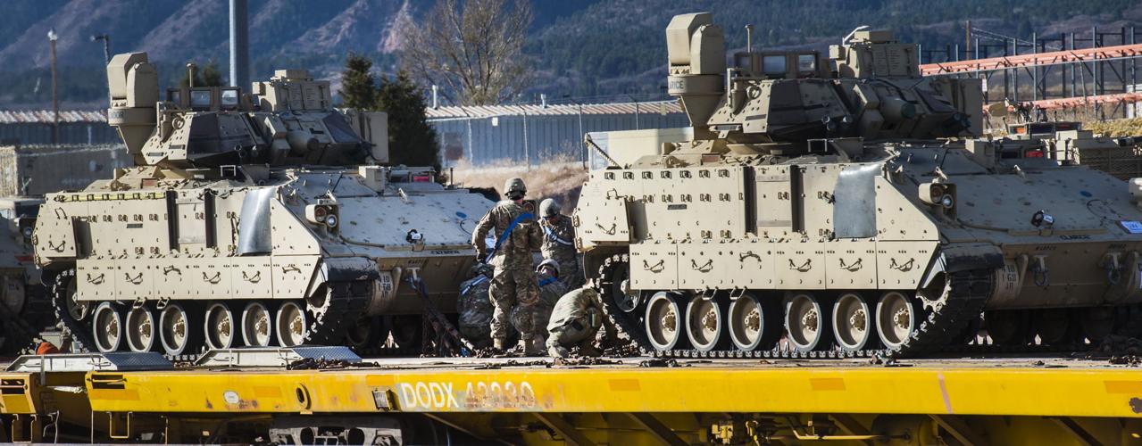 Soldiers tie down Bradley Fighting Vehicles to the deck of a rail car Tuesday, Nov. 29, 2016, as the 3rd Armored Brigade Combat Team, 4th Infantry Division loads track and wheeled vehicles onto rail cars at Fort Carson. The 2,800 vehicles are bound for ...